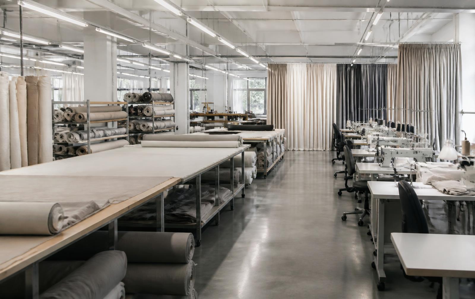 Curtain manufacturing workroom with fabric rolls and finished curtains
